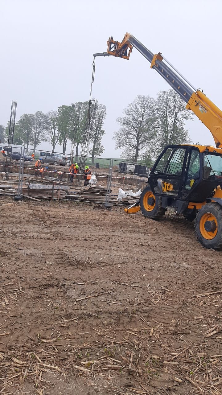 Podnoszenie palet z materiałami budowlanymi ładowarką teleskopową